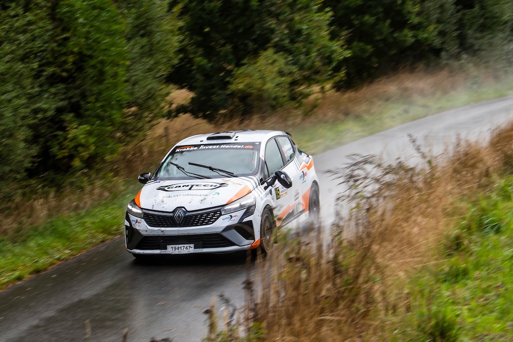 Jacob Pallesen og Kasper Pinholt kom ud på en meget krævende opgave på de regnvåde veje i Rally Sønderjylland. Her er de lynskudt i deres Renault Clio Rally5 på den 26 kilometer lange hastighedsprøve ved Genner.
(Foto: Jokum Tord Larsen)